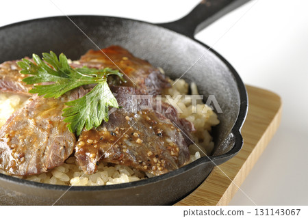 Garlic rice topped with grilled meat photographed on a white background Garlic rice topped with grilled meat photographed on a white background 131143067
