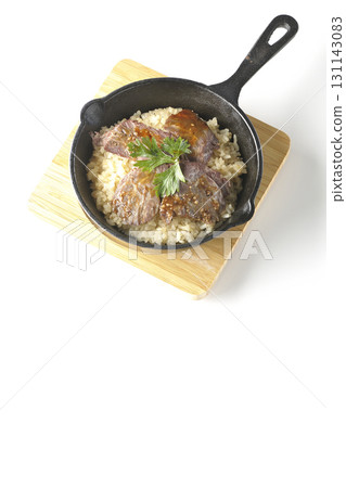 Garlic rice topped with grilled meat photographed on a white background Garlic rice topped with grilled meat photographed on a white background 131143083