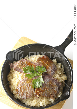 Garlic rice topped with grilled meat photographed on a white background Garlic rice topped with grilled meat photographed on a white background 131143085