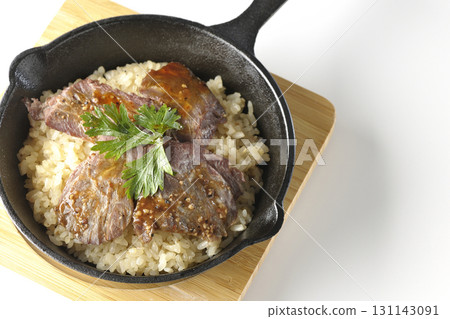 Garlic rice topped with grilled meat photographed on a white background Garlic rice topped with grilled meat photographed on a white background 131143091