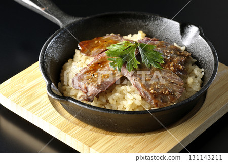 黑色背景下拍攝的蒜香米飯配烤肉 131143211