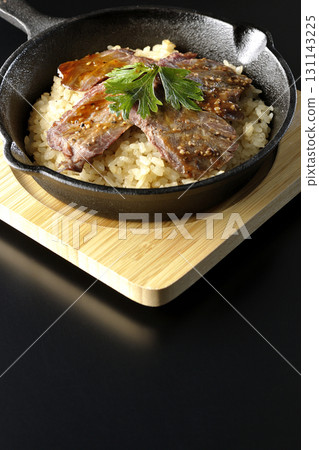 黑色背景下拍攝的蒜香米飯配烤肉 131143225