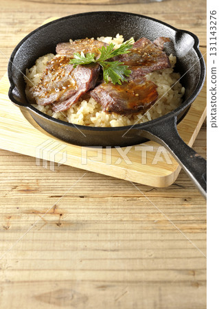 Garlic rice topped with grilled meat 131143276