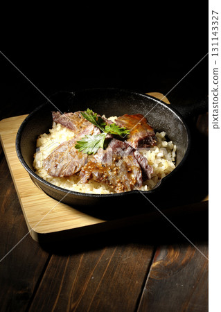 Garlic rice topped with grilled meat 131143327