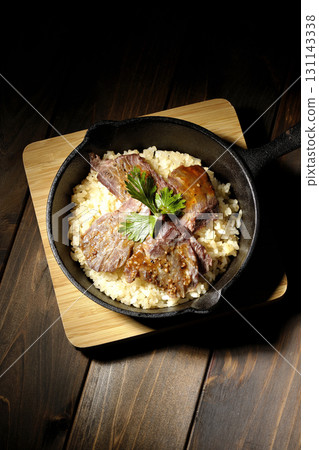 Garlic rice topped with grilled meat 131143338