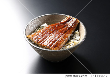 Eel bowl photographed alone against a black background 131143657