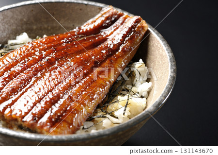 Eel bowl photographed alone against a black background 131143670