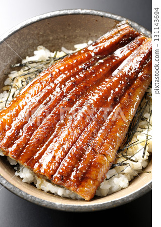 Eel bowl photographed alone against a black background 131143694