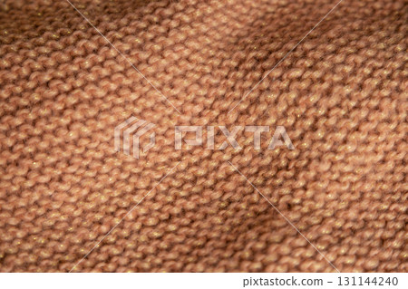 Brown canvas knitted with knitting needles. View from above. Knitted things. Brown canvas knitted with knitting needles. View from above. Knitted things. 131144240