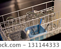Clean glassware arranged in a dishwasher basket ready for drying and storage in a modern kitchen 131144333
