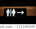 Restroom sign featuring male and female symbols with directional arrow for guidance 131144340