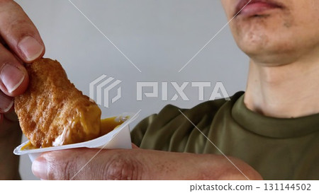 Person eating chicken nuggets 131144502