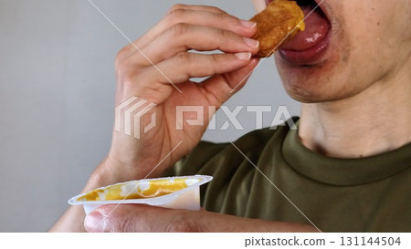 Person eating chicken nuggets 131144504