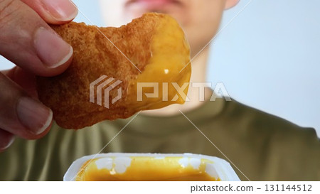 Close-up of a person eating chicken nuggets 131144512