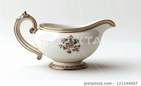 Elegant Creamy White Porcelain Gravy Boat with Ornate Golden Trim and Floral Accent on a Soft Background 131144887