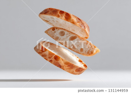 Three slices of sourdough bread levitate gracefully against a minimalist background, showcasing their unique texture and airiness 131144959