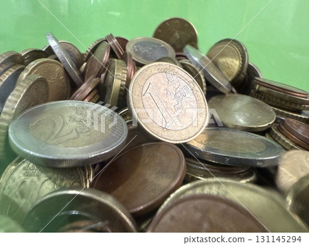 Close-up of Euro coins in container. Glass piggy bank for money. Saving money to buy necessary things. Close-up of Euro coins in container. Glass piggy bank for money. Saving money to buy necessary things. 131145294