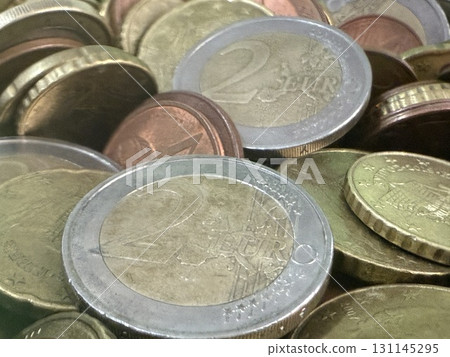 Close-up of Euro coins in container. Glass piggy bank for money. Saving money to buy necessary things. 131145295