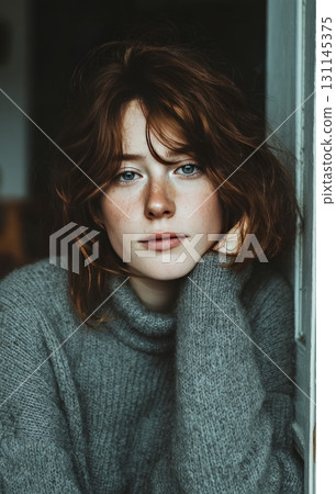 Young woman with red hair looking introspectively 131145375