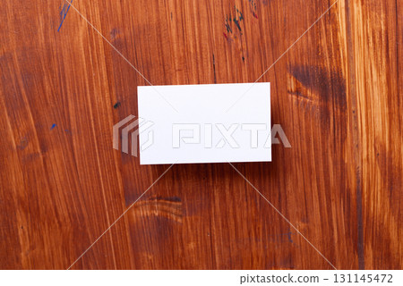 White card on wood grain background 131145472
