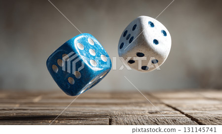 Floating Dice. A pair of blue and white dice suspended in air over a wooden surface 131145741
