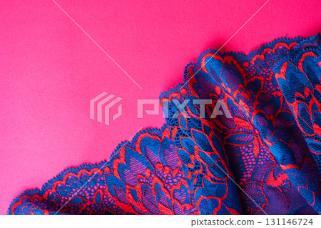 Blue lace fabric detail with floral pattern on pink surface 131146724