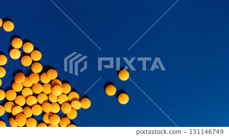 Many orange tablets on blue background, copy space 131146749