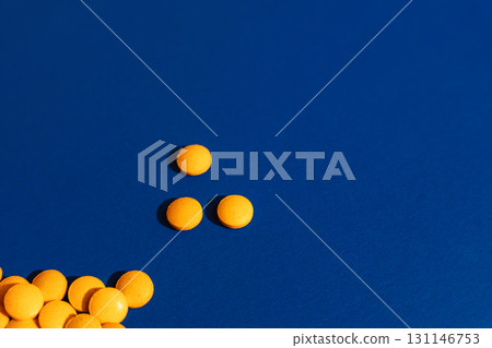 Orange tablets on blue background, minimal layout 131146753