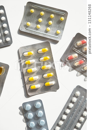 Various medicine pill and capsule blister packs on white surface. Various medicine pill and capsule blister packs on white surface. 131148268
