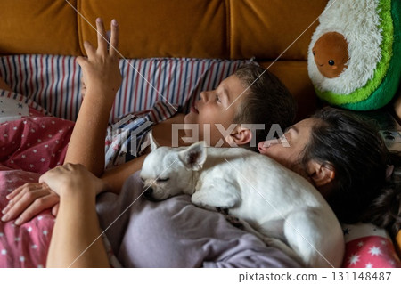 Mother, child, and dog enjoying morning family time in bed Mother, child, and dog enjoying morning family time in bed 131148487