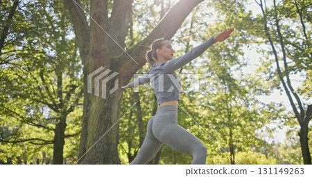 young beautiful white girl doing yoga in park among trees in clearing on summer day young beautiful white girl doing yoga in park among trees in clearing on summer day 131149263