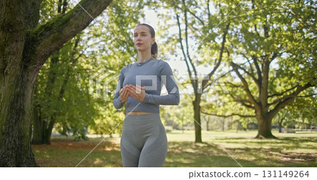young beautiful white girl doing yoga in park among trees in clearing on summer day young beautiful white girl doing yoga in park among trees in clearing on summer day 131149264