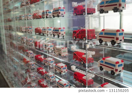 Fire engines and ambulances made from blocks lined up in an acrylic case 131150205
