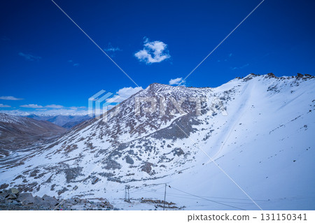 Himalayan mountain ridge blanketed with patches of snow 131150341