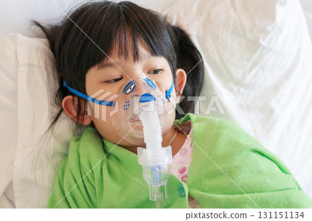 Sick little asian girl inhalation with nebulizer for respiratory treatment 131151134