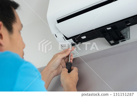 Electrician man repair and maintenance air conditioner 131151287