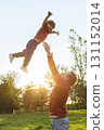 Father tossing his joyful son into the air in a park 131152014