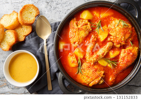 Chicken Bouillabaisse made with chicken, potatoes, takes its inspiration from the famous fish stew of the South of France closeup in the saucepan. Horizontal top view Chicken Bouillabaisse made with chicken, potatoes, takes its inspiration from the famous fish stew of the South of France closeup in the saucepan. Horizontal top view 131152833