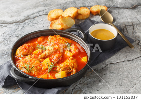 Chicken Bouillabaisse cooked in a delicious rich and fragrant broth closeup in the saucepan. Horizontal 131152837