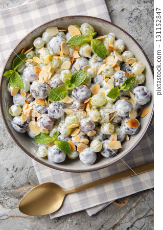 Close-up of grape mix salad with almonds dressed with creamy cheese sauce in a plate. Vertical top view 131152847