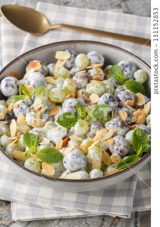 Freshly made grape salad with almonds and brown sugar sprinkled on top with creamy cheese dressing closeup in the plate. Vertical Freshly made grape salad with almonds and brown sugar sprinkled on top with creamy cheese dressing closeup in the plate. Vertical 131152853