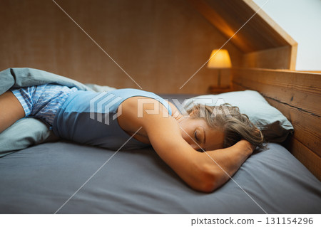 A beautifully peaceful scene featuring a person resting quietly and comfortably in a cozy, minimalist bedroom A beautifully peaceful scene featuring a person resting quietly and comfortably in a cozy, minimalist bedroom 131154296