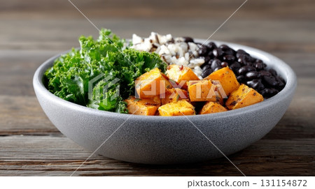 Enjoy a hearty fiber-rich vegan bowl featuring roasted sweet potatoes, leafy greens, and black beans Enjoy a hearty fiber-rich vegan bowl featuring roasted sweet potatoes, leafy greens, and black beans 131154872