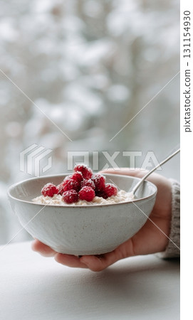 Fresh berries are gently placed on top of warm oatmeal, promoting healthy eating habits 131154930