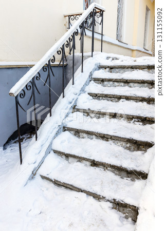 Ice covered concrete staircase is blanketed in fresh snow 131155092
