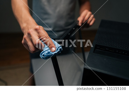 Cropped shot of technician cleaning glass panel of computer case with microfiber cloth, ensuring dust and fingerprints removed for optimal appearance and performance. Concept of service, cleaning PC. Cropped shot of technician cleaning glass panel of computer case with microfiber cloth, ensuring dust and fingerprints removed for optimal appearance and performance. Concept of service, cleaning PC. 131155108