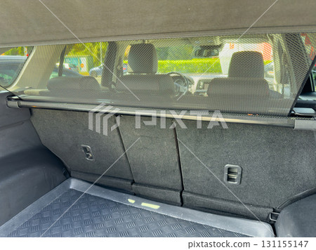 Rear cargo area of a vehicle displaying a protective cargo cover for improved privacy and organization during travel 131155147