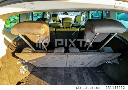 View of the spacious trunk area in a modern vehicle with rear seats folded down for storage convenience 131155232