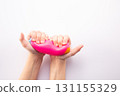 Hand squeeze pink stress ball on white background. Positive thinking concept. Copy space 131155329