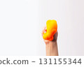 Hand squeeze orange stress ball on white background. Positive thinking concept. Copy space 131155344